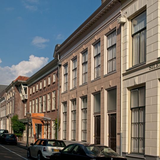 Pand met brede gepleisterde gevel met rechte kroonlijst op modillons