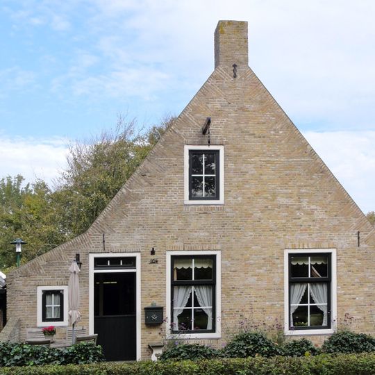 Pand met gecementeerde gevel, zesruitsvensters en houten goot op blokken onder aan de voorzijde afgewolfd zadeldak