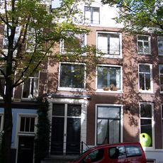 Pand met gevel onder houten in- en uitgezwenkte top met hoekconsoles en snijwerk om het zoldervenster