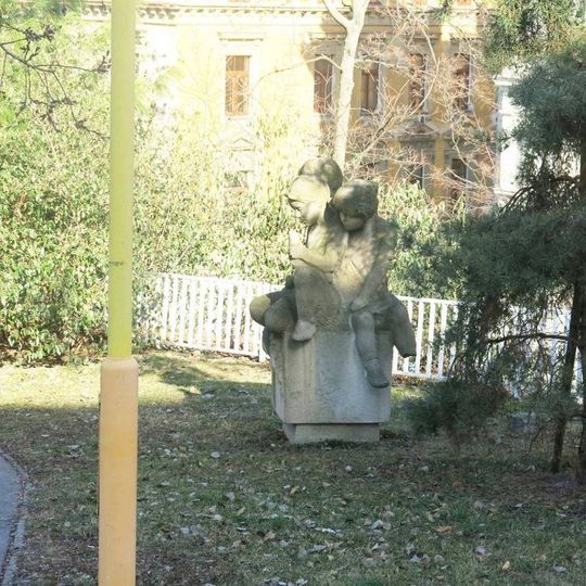 Socha dětí v zahradě školky ve Vozové ulici na Vinohradech