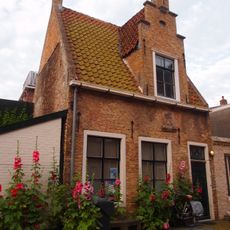 Pandje onder dwarskap met Vlaamse topgevel waarin trapgevel en gevelsteen met schip