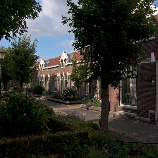 Complex arbeiderswoningen met bijbehorende tuinmuurtjes met hekwerken