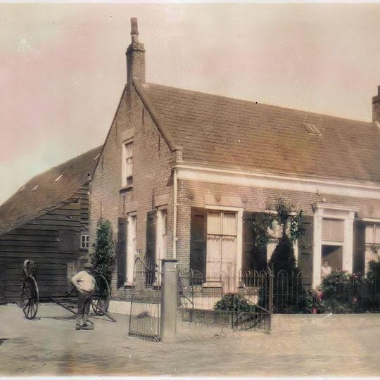 Woning, een bouwlaag hoog met kap, met een symmetrische rode bakstenen lijstgevel met gele bakstenen strekken boven de gevelopeningen