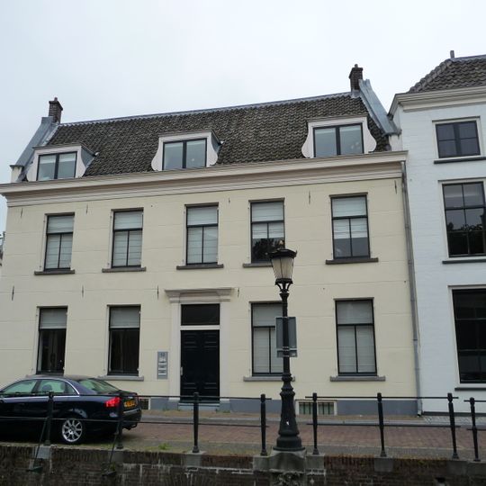 Pand met gevel met rechte getande kroonlijst, zadeldak en topgevels aan de korte zijde, gepleisterd