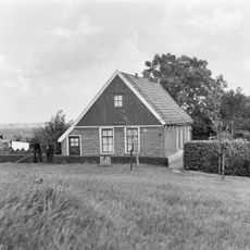 Huisje, nabij de Hervormde Kerk van Haringhuizen, onder zadeldak met houten geveltoppen en met zesruitsschuifvensters