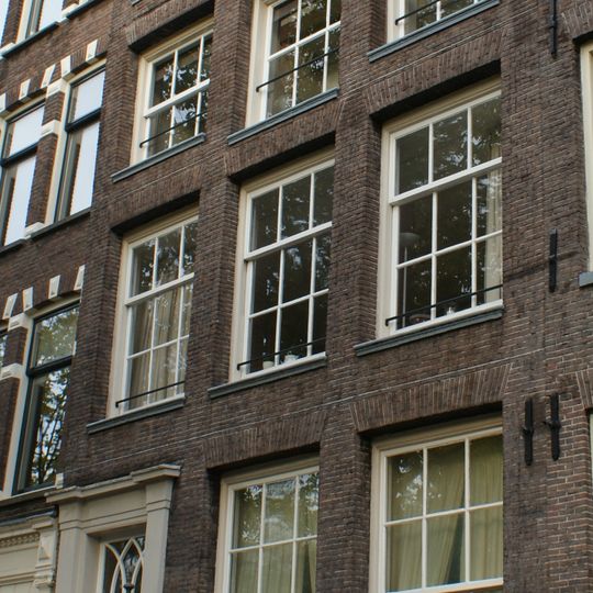 Pand met gevel onder gebeeldhouwde verhoogde lijst