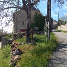 Croix en fer avec un jesus dessu sur socle en pierre