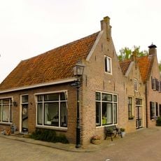 Pand met topgevel met toppilaster en gewijzigde gevel aan de Kathoek