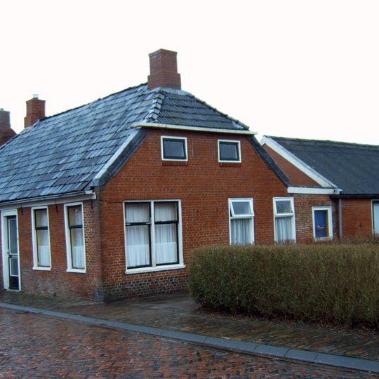 Pand onder zadeldak met wolfseinden en hoekschoorstenen