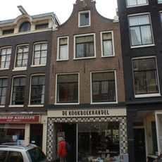 Huis met gevel onder klokvormige top met rollagen