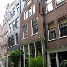 Huis met latere gevel onder klokvormige top met rollagen