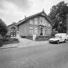 Woonhuis met praktijkruimte en aangebouwd koetshuis in ambachtelijk-traditionele stijl met Chaletstijl-invloeden