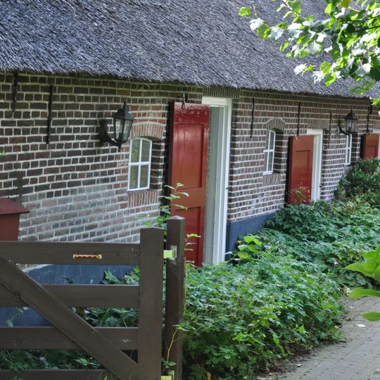 Goed bewaarde boerderij. Rietendak; vensters met luiken en ramen met roedenverdeling uit de bouwtijd. In de linkerzijgevel een venster met oud kozijn, waarin geprofileerde middenstijl