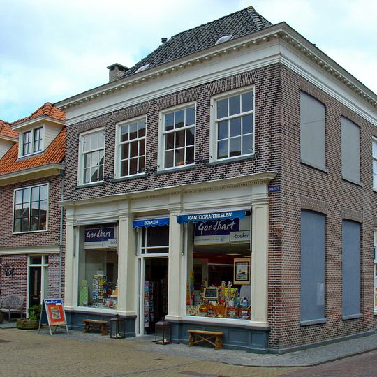 Hoekpand met negenruitsvensters op de verdieping onder schilddak met kroonlijst op klossen