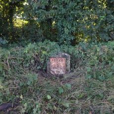 Milestone, just E of entrance to Claydon Fields.
