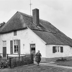 Witgepleisterd boerderijtje onder rieten wolfdak