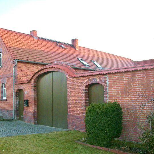 Bauernhof mit Wohnhaus, Seitengebäude und Hofmauer mit einem großen Torbogen und zwei kleinen Pforten, dazu Feldscheune Dorfstraße 61