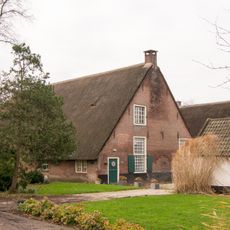 Boerderij met hoog rieten zadeldak en voorgevel met vlechtingen