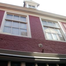 Pandje onder dwarskap met ontlastingsbogen met kopjes in de gevel