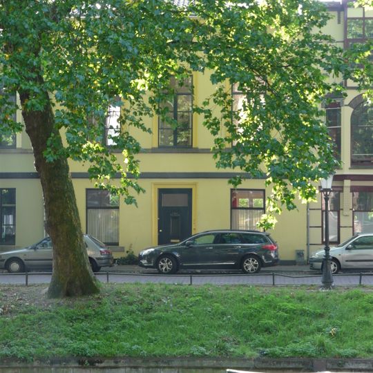 Pand, geheel gepleisterd, met verdieping en mezzanino onder flauwhellend zadeldak