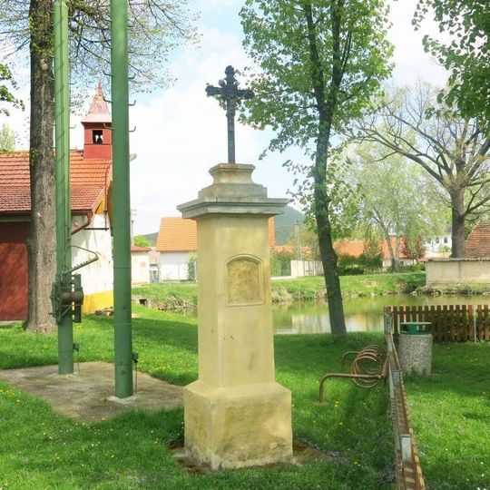 Kříž na návsi u rybníka v Mnetěši