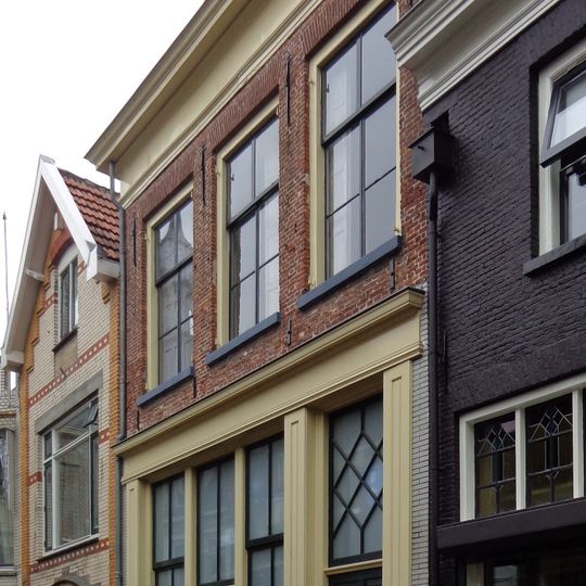 Huis met lijstgevel, omlijste voordeur met bovenlicht en dakkapel