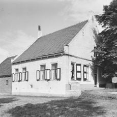 Boerderij met wit geverfd woonhuis onder rood pannen zadeldak