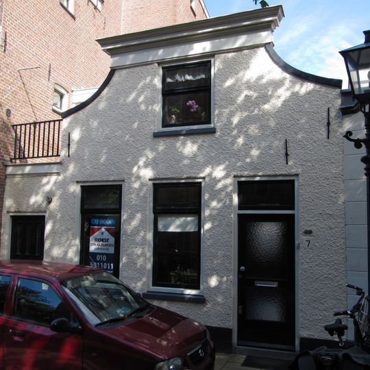 Pand met gepleisterde ingezwenkte gevel met rechte lijst