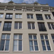 Pand met gevel onder zandstenen lijst met consoles en attiek waarin een tijger