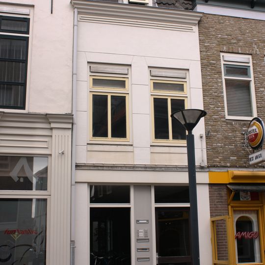 Pand met vedieping en schilddak. Gevel met houten kroonlijst, dakkapel met zijstukken