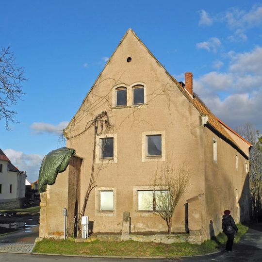 Wohnstallhaus eines ehemaligen Dreiseithofes, dazu Hofmauer mit Torbogen Dorfplatz 13; 13a