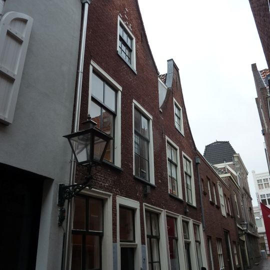 Pand met verdieping onder zadeldak met halsgevel waarin ongedeelde- en 6-ruitsschuifvensters in geprofileerde omlijstingen; 9-ruitsschuifvenster in top