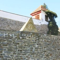 Kamenná plastika Boží oko na hradbě parkánu v Kadani