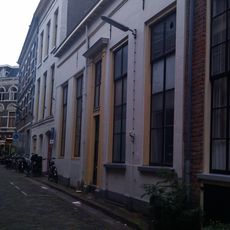 Eenvoudig dwarshuis van begane-grond met hoog zadeldak, dat niet de oorspronkelijke dakhelling heeft