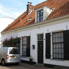 Laag gepleisterd hoekpand met rechte kroonlijst