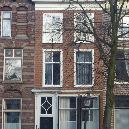 Pand met bakstenen lijstgevel. Lod. XIV deuromlijsting, goede pui. Hardstenen stoep en palen