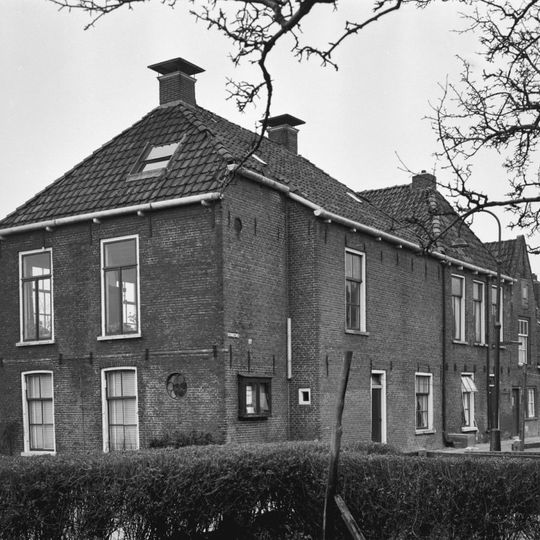 Pand met verdieping en door topschoorstenen bekroond schilddak met nokrichting loodrecht op het water
