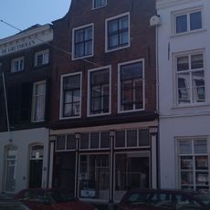 Pand met topgevel met in- en uitgezwenkte contouren, geprofileerde dekplaten en ontlastingsbogen