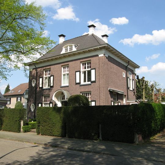 Blokvormige tweelaags villa met kolommen langs de straat