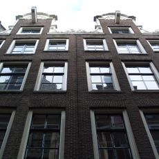 Pand met halsgevel met gedeelde vleugelstukken en palmet in de afdekking