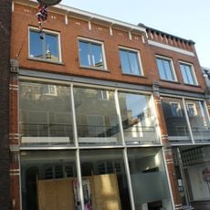 Pand achter het noordelijke deel een afgeknotte trapgevel, met ontlastingsbogen in rode steen