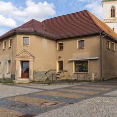 Ehemaliger Gasthof mit Gebäudeflügeln um einen geschlossenen Innenhof Am Dorfplatz 17