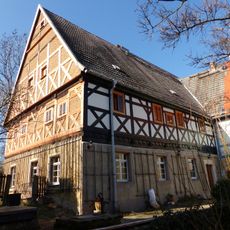 Pfarrhof mit Wohnhaus und Wohnstallhaus (im Winkel aneinandergebaut) sowie Brunnen mit Handschwengelpumpe Pfarrweg 3a; 3b