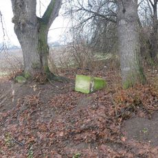 Povalený podstavec s ulomeným křížem u silnice západně od Hošnic