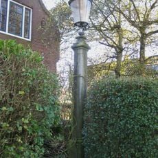 In de tuin een hardstenen lantaarnpaal