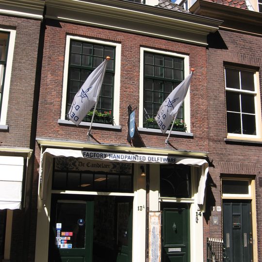 Woonhuis van parterre en verdieping met lijstgevel, waarin oorspronkelijke deur met bovenlicht en kalf. Links inrijdeur. In de verdieping zesruitsschuiframen