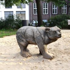 Hölzerner Bär auf den Spielplatz im Sandkasten.