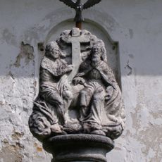 Sloup s plastikou světců na boku bývalé fary ve středu Vojtíškova