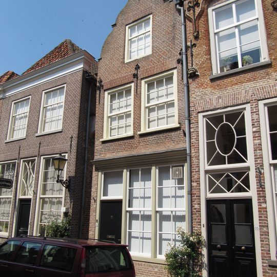 Huis met in- en uitgezwenkte topgevel, beganegronds samengetrokken met de winkel van het vorige huis