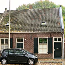 Gepleisterd wevershuisje van begane-grond met pannen zadeldak